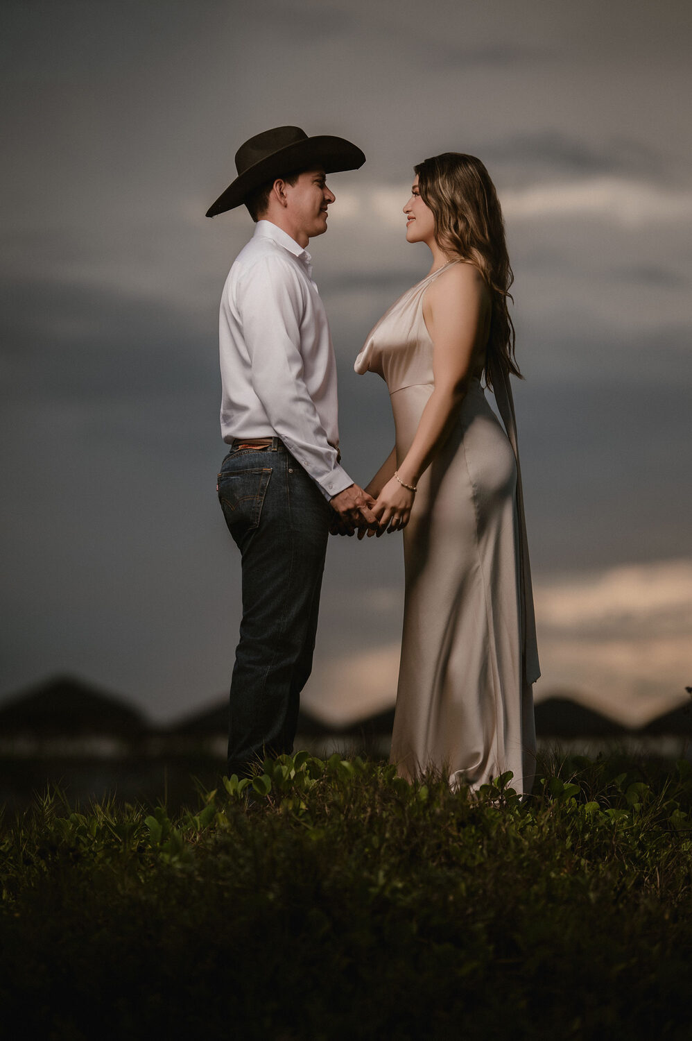 Fátima y Azael en una silueta romántica contra el cielo del atardecer